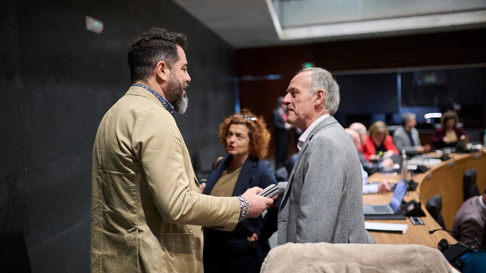 Ramón Alzórriz, del PSN, habla con Adolfo Araiz, de EH Bildu, minutos antes del comienzo del pleno del Parlamento. PABLO LASAOSA