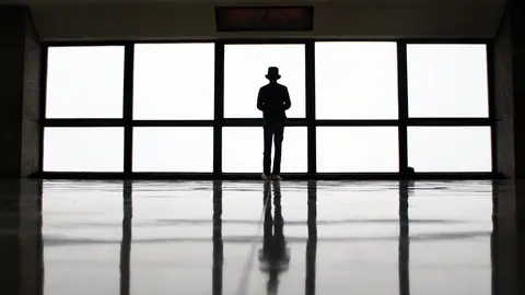 Un hombre mira por una ventana en soledad