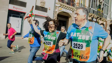 Itziar G&oacute;mez (Geroa Bai-PNV) y el alcalde Joseba Asir&oacute;n (Bildu) corren con la ikurri&ntilde;a durante la Korrika en Pamplona