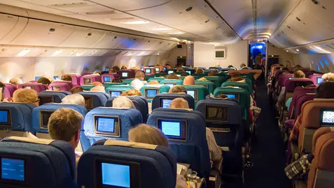Varioas personas viajan en el interior de un avi&oacute;n.
