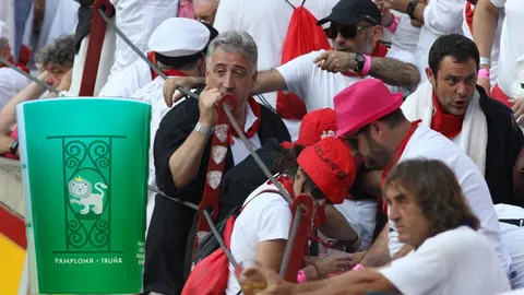 Imagen del vaso reutilizable implantado en los Sanfermines junto a una fotografía del alcalde de Pamplona, Joseba Asirón, durante una de las últimas corridas de la Feria del Toro NAVARRACOM