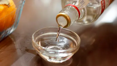 Un camarero sirve un chupito de anís en un vaso pequeño sobre una barra de bar ARCHIVO