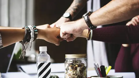 Varias personas chocan sus pu&ntilde;os.