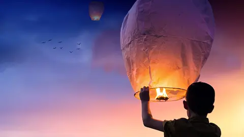 Un ni&ntilde;o lanza un farolillo con motivo del a&ntilde;o nuevo como s&iacute;mbolo de un deseo para cumplir.