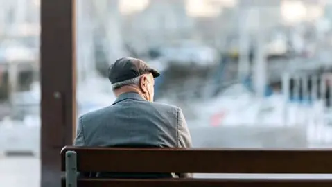 Un hombre, s&oacute;lo en un banco de la calle.