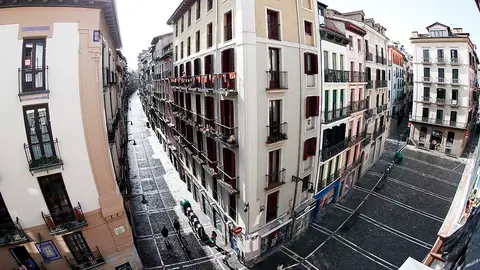 Un grupo de personas separados entre ellos, esperan realizar la compra en un comercio de la Calle Estafeta de Pamplona donde el resto de negocios permanecen cerrados dejando estos días la calle completamente vacía tras el estado de alarma decretado es España que limita el movimiento de los ciudadanos salvo las excepciones contempladas en el decreto para evitar el contagio y la propagación del COVID-19.  EFE/ Jesús Diges