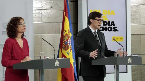 El ministro de Sanidad, Salvador Illa, y la portavoz del Gobierno, María Jesús Montero, durante la rueda de prensa por videoconferencia para abordar la evolución del coronavirus en España. En Madrid, (España), a 17 de abril de 2020. - Moncloa. Europa Press.