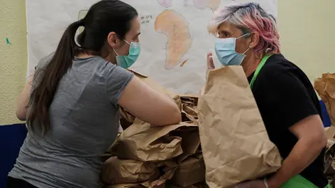Dos voluntarias preparan bolsas con menús de comida que contienen un táper con comida y fruta en el colegio Ramón María del Valle Inclán de San Blas, desde donde se reparten para que cada día de la semana puedan comer unas 800 personas, con alrededor de la entrega por el patio del colegio de más de 400 raciones diarias que proceden del mercado de Santa Eugenia, en Madrid (España), a 20 de mayo de 2020.
20 MAYO 2020 CORONAVIRUS;COVID-19;ESTADO DE ALARMA;COMIDA;
Jesús Hellín / Europa Press
  (Foto de ARCHIVO)
20/5/2020