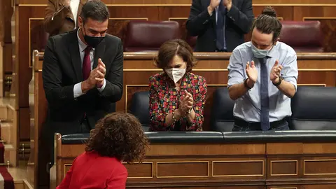 El presidente del Gobierno, Pedro S&aacute;nchez; la vicepresidenta primera y ministra de la Presidencia, Relaciones con las Cortes y Memoria Democr&aacute;tica, Carmen Calvo; y el vicepresidente de Derechos Sociales y Agenda 2030, Pablo Iglesias; aplauden a la ministra de portavoz y de Hacienda, Mar&iacute;a Jes&uacute;s Montero.