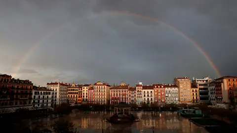Un arcoiris hace su aparición este lunes sobre la céntrica Plaza del Castillo de Pamplona en una jornada en la que el cielo estará cubierto con lluvias y chubascos en la capital navarra y la cota de nieve subirá a entre 1.000-1.200 metros. EFE/Villar López