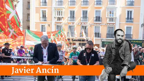 Joseba Asir&oacute;n corta la cinta de la etapa de la vuelta ciclista al Pa&iacute;s Vasco rodeado de ikurri&ntilde;as.