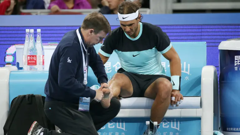 Rafa Nadal es atendido por el médico en un descanso. Efe.