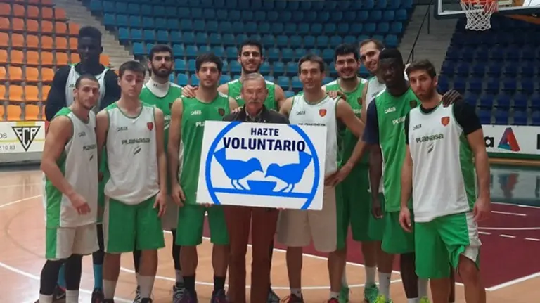 Los jugadores del Planasa posan con el cartel "hazte voluntario".