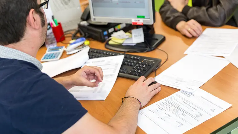 Un funcionario trabaja en la oficina de Hacienda en el primer día de campaña que se puede presentar la declaración de la renta de 2016 de forma presencial. IÑIGO ALZUGARAY