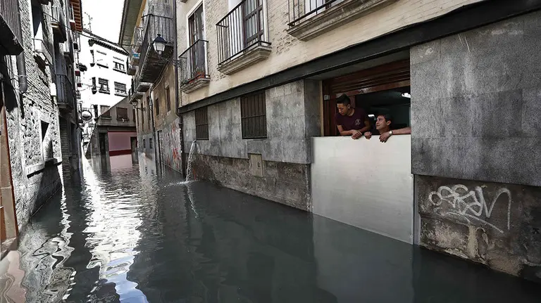 GRAF3188. TUDELA(PAMPLONA) (ESPA&Ntilde;A), 13/04/2018.- Dos personas observan como se encuentran las calles del casco viejo de Tudela, tras la inundaci&oacute;n que ha sufrido el casco viejo de la ciudad por la crecida del rio Ebro. La alerta por inundaciones se mantiene a estas horas en Navarra en dos estaciones de aforo, la del Ebro en Castej&oacute;n y la del Ega en Andosilla, mientras que en Pamplona desciende el caudal de los r&iacute;os y se va recuperando la normalidad tras los desbordamientos de ayer. EFE/Jes&uacute;s Diges