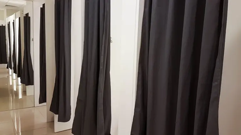 Imagen de varios probadores de ropa en una tienda junto a un espejo de fondo ARCHIVO