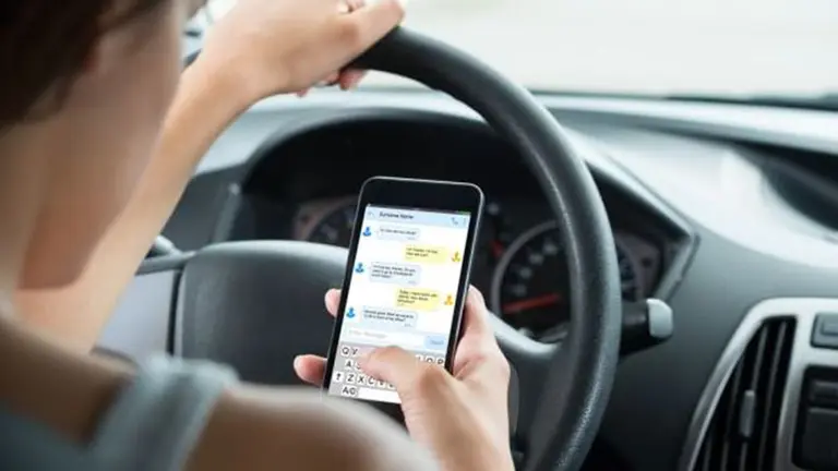 Una persona circula en coche mientras utiliza el móvil ARCHIVO