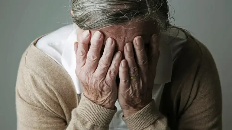 Una anciana cubre su cara con sus manos. ARCHIVO