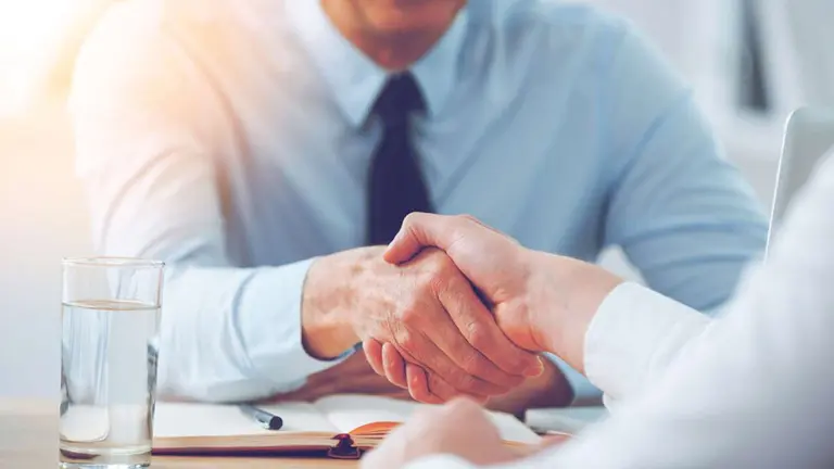 Dos personas se dan la mano durante una entrevista de trabajo ARCHIVO