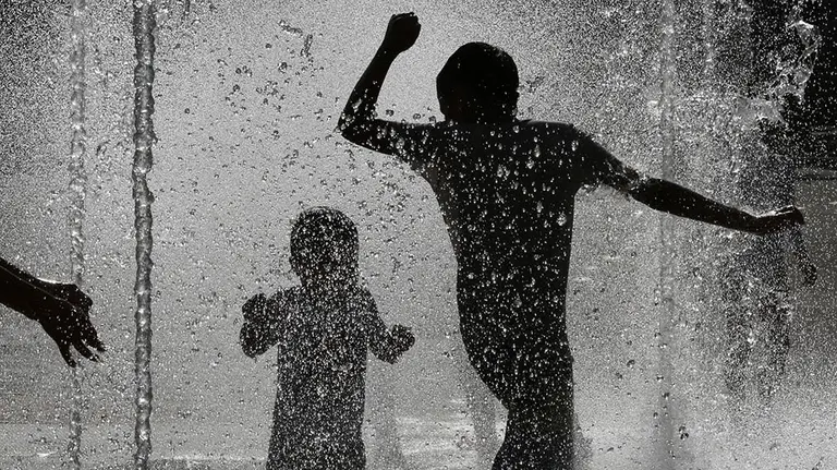 Varios j&oacute;venes combaten las altas temperaturas registradas este s&aacute;bado en Pamplona refresc&aacute;ndose en una de las fuentes de la capital navarra. Aemet ha informado de que hoy se han dado las temperaturas m&aacute;s altas de este episodio de ola de calor en Navarra. EFE/Villar L&oacute;pez.