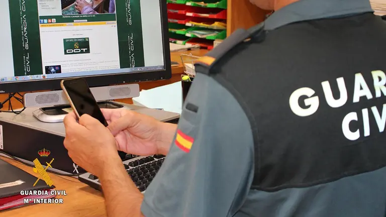 Un agente de la Guardia Civil investiga un m&oacute;vil en el ordenador. GUARDIA CIVIL / ARCHIVO