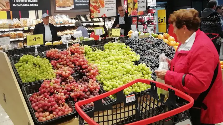 Varias personas comprando en un supermercado EROSKI