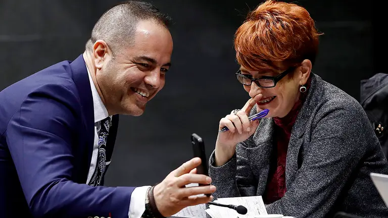 El parlamentario y secretario de Organizaci&oacute;n del PSN Ram&oacute;n Alzorriz (i) bromea con la parlamentaria de EH Bildu Bakartxo Ruiz, tras la votaci&oacute;n celebrada este jueves en el Parlamento de Navarra que ha aprobado los Presupuestos Generales de Navarra para 2020 con modificaciones de escasa cuant&iacute;a y una medida de protecci&oacute;n para inquilinos de viviendas sociales descalificadas. EFE/Jes&uacute;s Diges