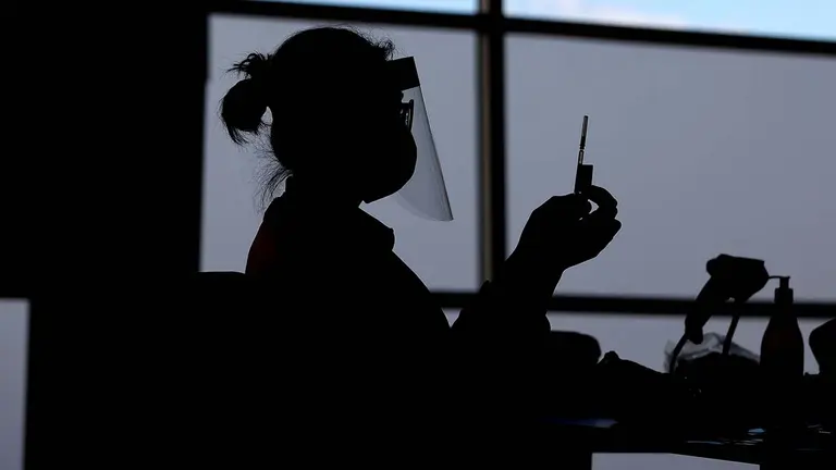 Una enfermera sujeta una vacuna de Pfizer. AAP Image/Brendon Thorne