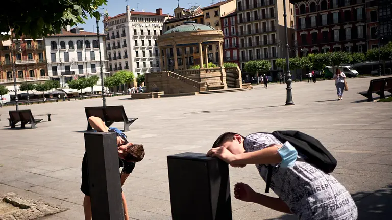 Dos j&oacute;venes beben agua de una fuente durante la ola de calor en junio de 2022. PABLO LASAOSA