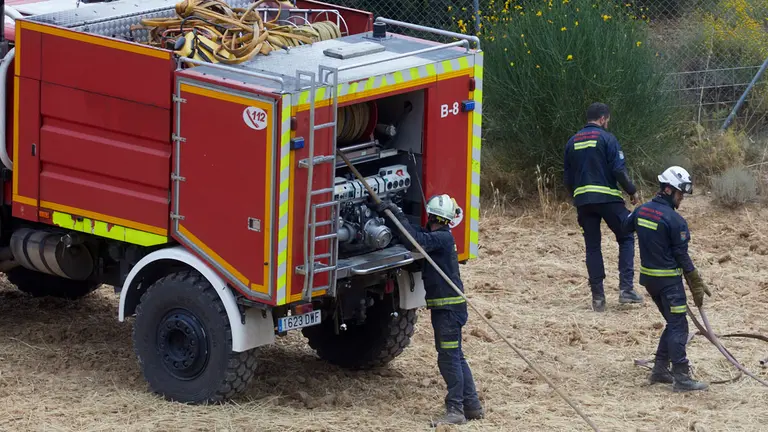 Un retén de bomberos trabajan en la extinción y control del incendio de la sierra del Perdón. IÑIGO ALZUGARAY