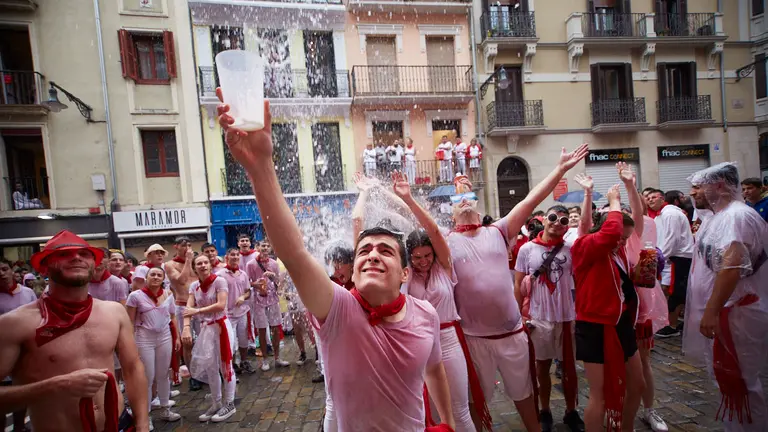 Lanzamiento de agua desde los balcones de la calle Mercaderes en los momentos posteriores al Chupinazo con el que se ha dado inicio a los Sanfermines 2022. I&Ntilde;IGO ALZUGARAY