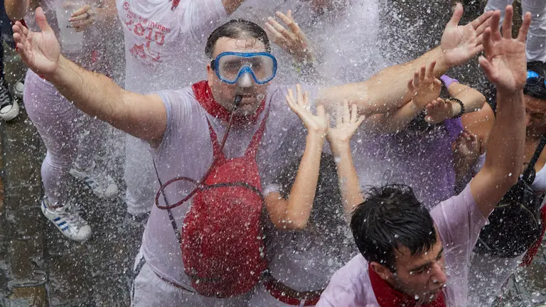 Lanzamiento de agua desde los balcones de la calle Mercaderes en los momentos posteriores al Chupinazo con el que se ha dado inicio a los Sanfermines 2022. I&Ntilde;IGO ALZUGARAY