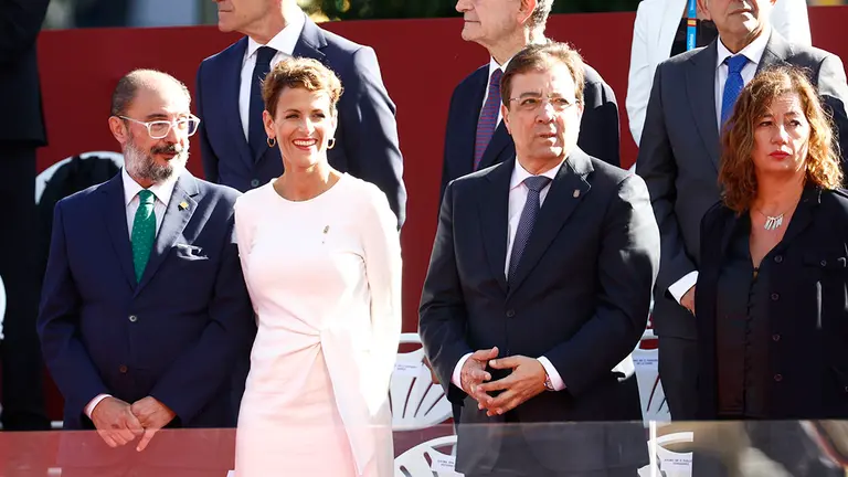 MADRID, 12/10/2022.- Los presidentes de Arag&oacute;n, Javier Lamb&aacute;n (i); Navarra, Mar&iacute;a Chivite  (2i); Extremadura, Guillermo Fern&aacute;ndez Vara y Baleares, Francina Armengol (d), en el palco de autoridades durante el desfile del D&iacute;a de la Fiesta Nacional, este mi&eacute;rcoles, en Madrid. EFE/ Rodrigo Jim&eacute;nez
