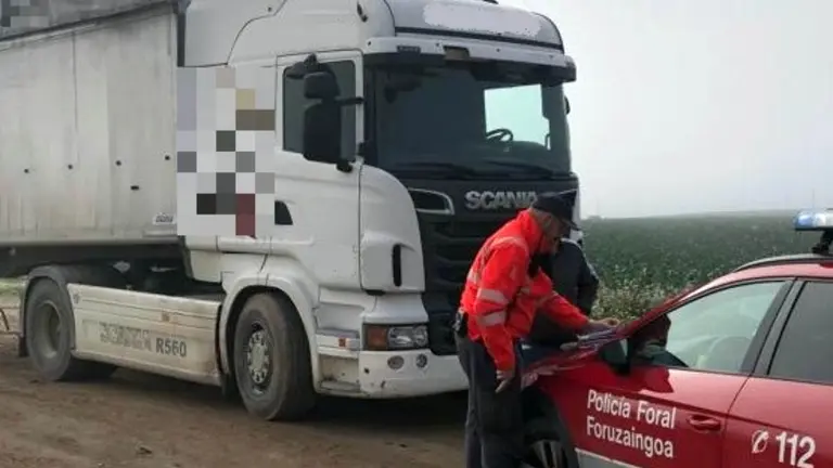 El cami&oacute;n inmovilizado junto a los agentes que han denunciado a su conductor. POLIC&Iacute;A FORAL