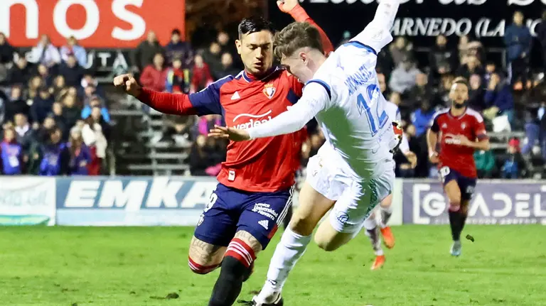 El delantero argentino de Osasuna, el Chimy &Aacute;vila (i), disputa el bal&oacute;n ante el defensor del CD Arnedo durante el encuentro de la segunda eliminatoria de la Copa del Rey que han disputado este mi&eacute;rcoles en el campo municipal de Sendero, en Arnedo. EFE/Raquel Manzanares.