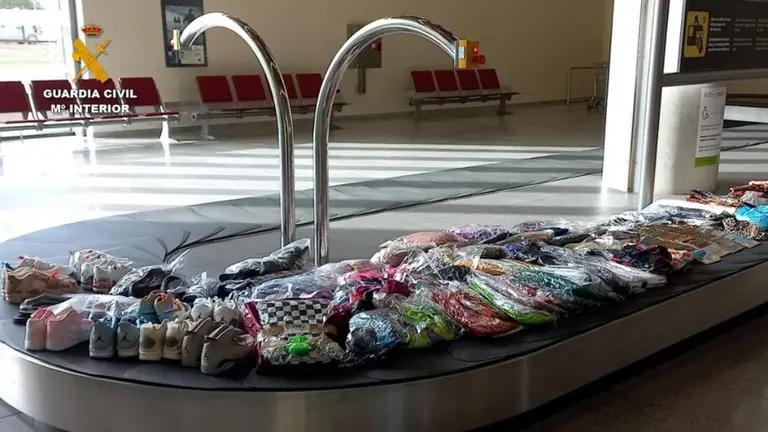Calzado, ropa y dem&aacute;s productos en la cinta transportadora del aeropuerto de Noain que el viajero pretend&iacute;a introducir entre su equipaje y que no hab&iacute;an pasado por el control de aduanas. GUARDIA CIVIL