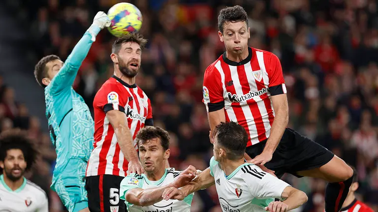 El guardameta de Osasuna, Aitor Fern&aacute;ndez (i), despeja el bal&oacute;n ante el defensa del Athletic Club, Yeray &Aacute;lvarez, durante el encuentro correspondiente a la jornada 16 de primera divisi&oacute;n que disputan hoy lunes en el estadio de San Mam&eacute;s, en Bilbao. EFE / Luis Tejido.