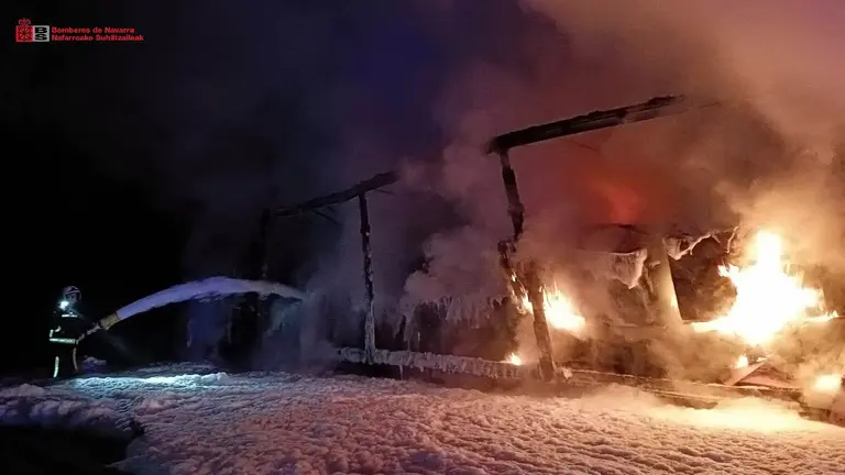 Un bombero trata de sofocar las llamas del cami&oacute;n siniestrado este jueves en Navarra. BOMBEROS DE NAVARRA
