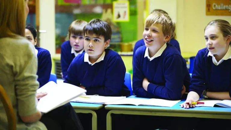 Alumnos con su profesora en un aula. ARCHIVO