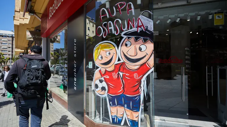 El pintor Alain Larreina y la Asociaci&oacute;n Ensanche &Aacute;rea Comercial han creado la iniciativa de los escaparates rojillos para que los locales de la zona luzcan dibujos relacionados con la final de Copa del Rey de Osasuna. I&Ntilde;IGO ALZUGARAY