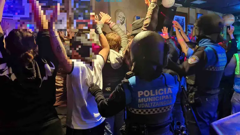 Momento de la redada y del os cacheos en un bar de la calle San Francisco de Pamplona. POLIC&Iacute;A MUNICIPAL DE PAMPLONA