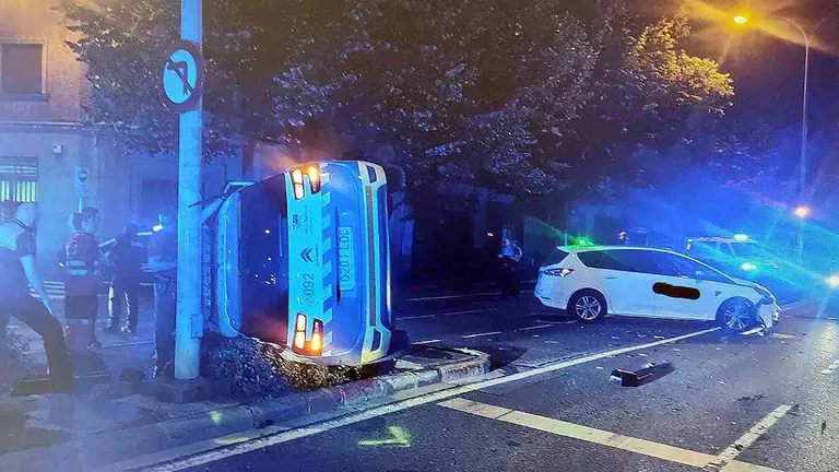 El coche patrulla termin&oacute; volcado  tras golpearse con un taxi. POLIC&Iacute;A MUNICIPAL DE PAMPLONA