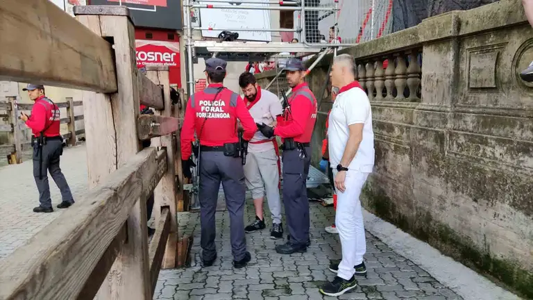 Dos agentes identifican al corredor del encierro que ha cometido la infracci&oacute;n. JIDQ