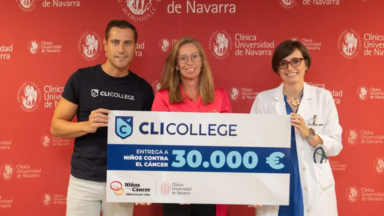 Pablo Fern&aacute;ndez entrega el cheque de 30.000 euros a Pilar Lorenzo, responsable de RSC de la Cl&iacute;nica Universidad de Navarra, entre profesionales sanitarios, pacientes y familiares. CEDIDA