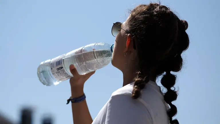 Una joven bebe agua para sofocar las altas temperaturas registradas este miércoles en Palas de Rei. Con una ola de calor en pleno apogeo, que podría empezar a remitir el viernes, todo el país se encuentra en alerta tras apuntalar hoy otra jornada de registros generalizados de más de 40 grados, mientras el País Vasco está con riesgo extremo, con 42 grados, y un aviso, el rojo, que mañana se extenderá al nordeste. EFE/ Eliseo Trigo