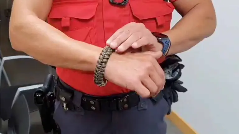 Un agente de la Polic&iacute;a Foral muestra la pulsera intervenida a un detenido. POLIC&Iacute;A FORAL