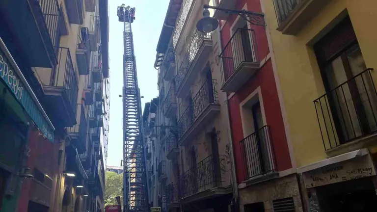 Un cami&oacute;n de bomberos supervisa la zona de la facha desprendida en la calle San Gregorio de Pamplona. EUROPA PRESS