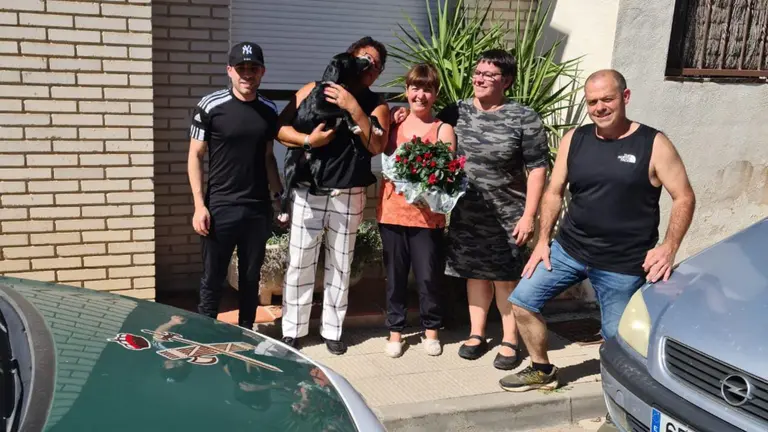 La familia posa con el perro recuperado en brazos. GUARDIA CIVIL