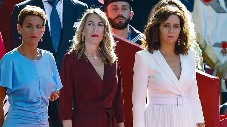 a presidenta de Navarra Mar&iacute;a Chivite (i-d), la presidenta de la Junta de Extremadura, Mar&iacute;a Guardiola, y la presidenta de la comunidad de Madrid, Isabel D&iacute;az Ayuso, este jueves durante el desfile del D&iacute;a de la Fiesta Nacional en Madrid, presidido por los reyes, en el que participan 4.177 militares, 86 aviones y helic&oacute;pteros y 142 veh&iacute;culos terrestres.EFE/ Chema Moya