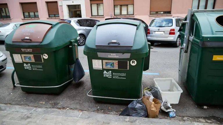 Contenedores de basura con bolsas en su exterior en la calle Doctor Huarte de San Juan en Pamplona. IÑIGO ALZUGARAY